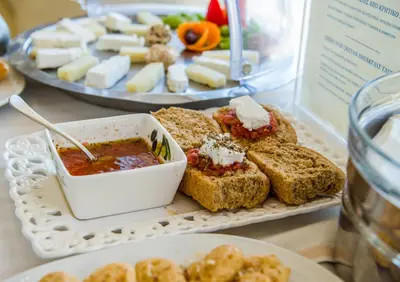a table with a tray of food with sandwiches and dips at ERIA RESORT for people with special abilities in Maleme