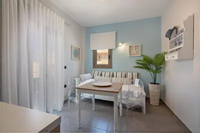 a kitchen and dining room with a table and chairs at Sonio Beach - Que Bella Collection in Plataniás