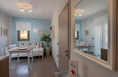 a dining room and living room with a table and a mirror at Sonio Beach - Que Bella Collection in Plataniás
