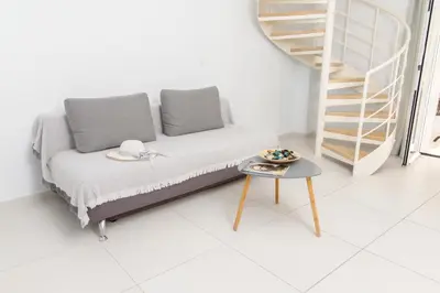 a couch with two pillows and a table in a room at Notus Chania Crete in Chania Town