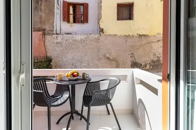 a table and two chairs on a balcony with a window at Notus Chania Crete in Chania Town
