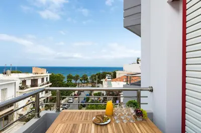a balcony with a table with a view of the ocean at La Vita Moderna in Chania Town