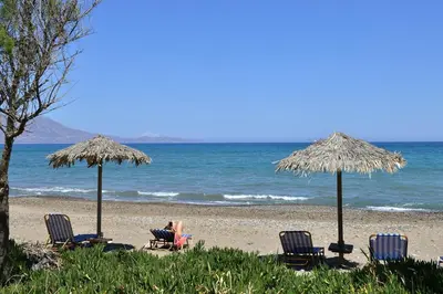 a group of chairs and umbrellas on a beach at Mousa Thalia in Kissamos