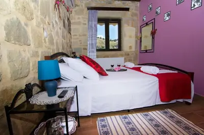 a bedroom with a bed with a blue lamp and a table at Mansion Rokka in Kissamos