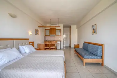 a bedroom with a bed and a couch and a kitchen at Castro Beach Hotel in Maleme