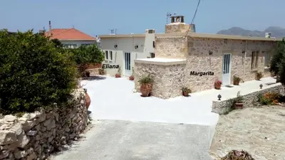 a house with a stone wall and a driveway at Margarita's Stone House in Plátanos