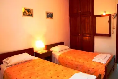 a hotel room with two beds and a mirror at Kalives Apartments in Kalyves