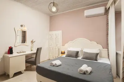 a bedroom with a bed with a desk and a chair at Elia Palazzo Hotel in Chania Town