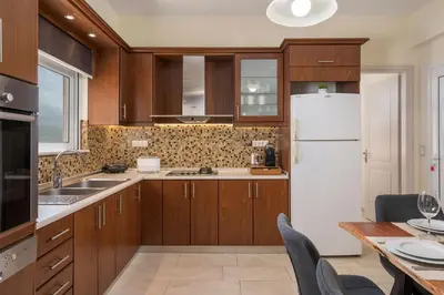 a kitchen with wooden cabinets and a white refrigerator at Casa Magnolia in Katokhórion