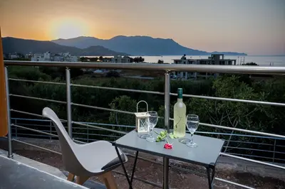 a table with a bottle of wine and two glasses at Villa Alexandra in Kissamos