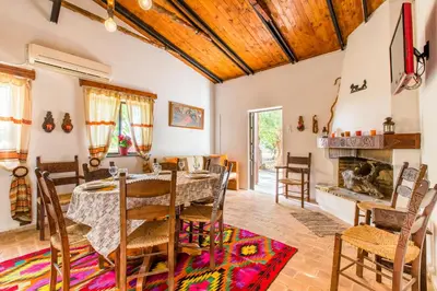a dining room with a table and chairs and a fireplace at Aadonis traditional house on the Sea in Kolymvari