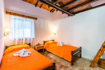 two beds in a room with orange sheets at Aadonis traditional house on the Sea in Kolymvari