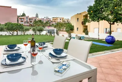a white table with glasses of wine on a patio at Olive Garden Holiday Home steps to Beach 1 in Kato Daratso