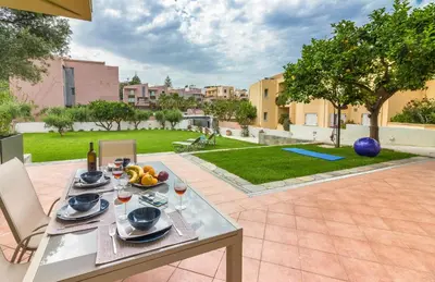a table with a plate of fruit and wine on it at Olive Garden Holiday Home steps to Beach 1 in Kato Daratso