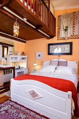 a bedroom with a large white bed and a staircase at Sali Chelidonaki boutique suite in Chania Town