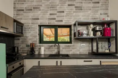 a kitchen with a sink and a brick wall at Zen Villa Elafonisi in Kamára