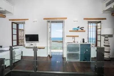 a living room with a view of the ocean at kito- transformed house on the water's edge in Chania Town
