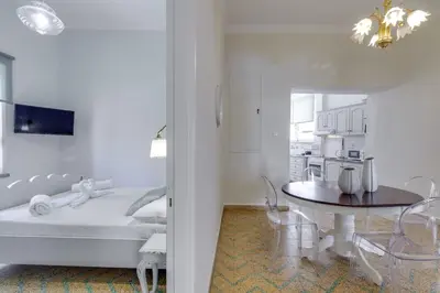 a white room with a table and a kitchen at Samouil Apartment steps from the beach in Chania Town