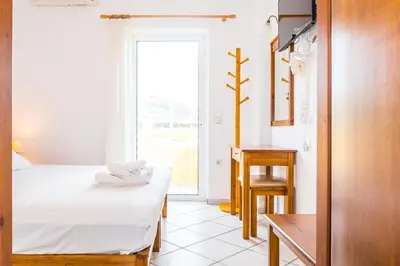 a room with a bed and a table and a window at Thalassa Apartments in Kissamos