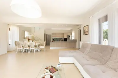 a white living room with a couch and a table at Eudora Luxury Stone Villa in Almirida