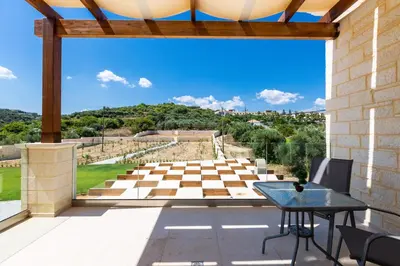 a view from the patio of a villa with a table and chairs at Eudora Luxury Stone Villa in Almirida