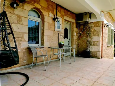 a patio with a table and chairs next to a building at Harmony House in Kissamos