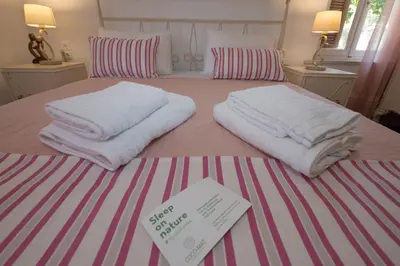 a bed with white towels and a sign on it at Harmony House in Kissamos