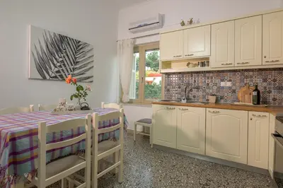 a kitchen with white cabinets and a table with a tablecloth at Harmony House in Kissamos