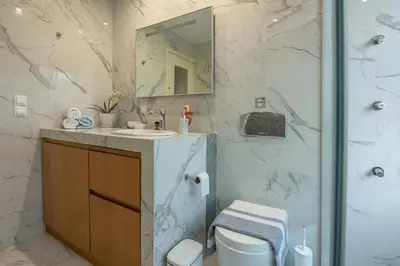 a bathroom with a sink and a toilet and a mirror at Harmony House in Kissamos