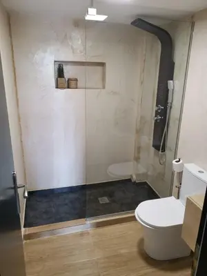 a bathroom with a glass shower with a toilet at Dali Rooms in Chania Town