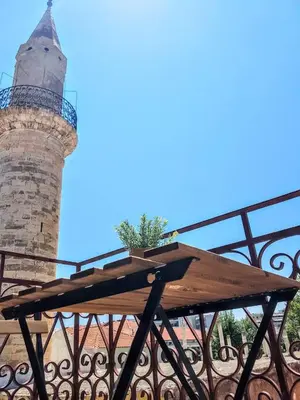 a wooden picnic table with a lighthouse in the background at Dali Rooms in Chania Town