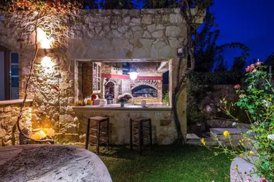 an outdoor kitchen in a stone building at night at Niko's art Villa in Chania in Perivólia