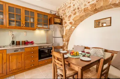 a kitchen with a table and a kitchen with an archway at Casa Emily in Chania Town