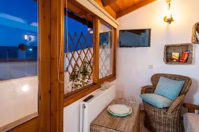 a room with a chair and a table and a window at Casa Emily in Chania Town