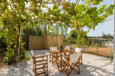 a wooden table and chairs under a tree at Femina in Pírgos Psilonérou