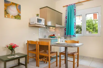 a kitchen with a table and chairs and a microwave at Armonia Apartments in Almirida