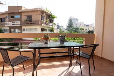 a table and chairs on a balcony with a view of a building at Plumi City Apartments in Chania Town
