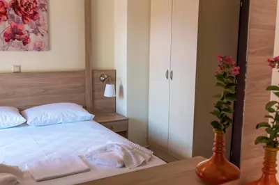 a bedroom with a bed and a vase with flowers at Plumi City Apartments in Chania Town