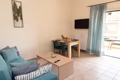 a living room with a blue couch and a table at Plumi City Apartments in Chania Town