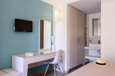 a room with a desk with a chair and a mirror at Poseidon Studios & Apartments in Palaiochóra