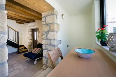 a dining room with a wooden table and a chair at Kyriaki's Traditional House in Galatás