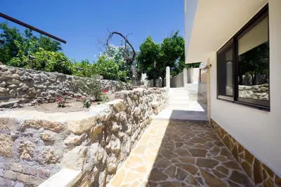 a stone retaining wall next to a building at Kyriaki's Traditional House in Galatás