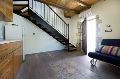 a living room with a staircase and a couch at Kyriaki's Traditional House in Galatás