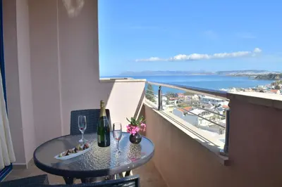 a table with wine glasses and a view of the ocean at Galini Sea View in Agia Marina Nea Kydonias