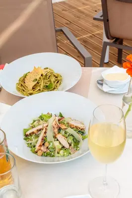 a table with two plates of food and a glass of wine at Dimitra & Evdokia Hotel in Agia Marina Nea Kydonias