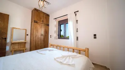 a bedroom with a bed with a mirror and a window at Estia in Plátanos