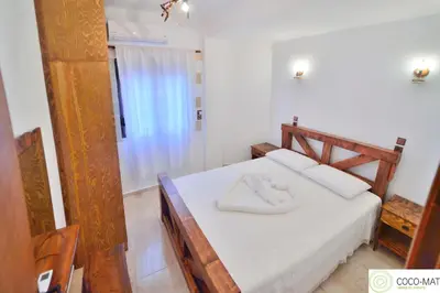 a bedroom with a bed with white sheets and a window at Estia in Plátanos