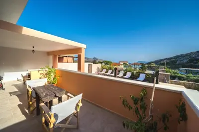 a balcony of a house with a table and chairs at Nemesis in Plátanos