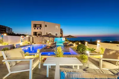 a patio with a table and chairs and a pool at Talos Luxury Suites in Kounoupidhianá