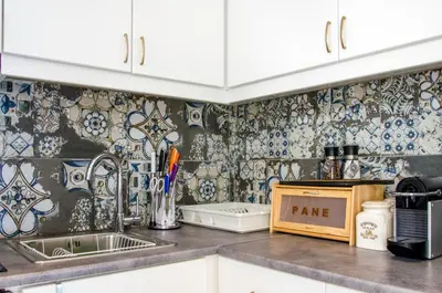 a kitchen with a sink and a tile wall at Talos Luxury Suites in Kounoupidhianá